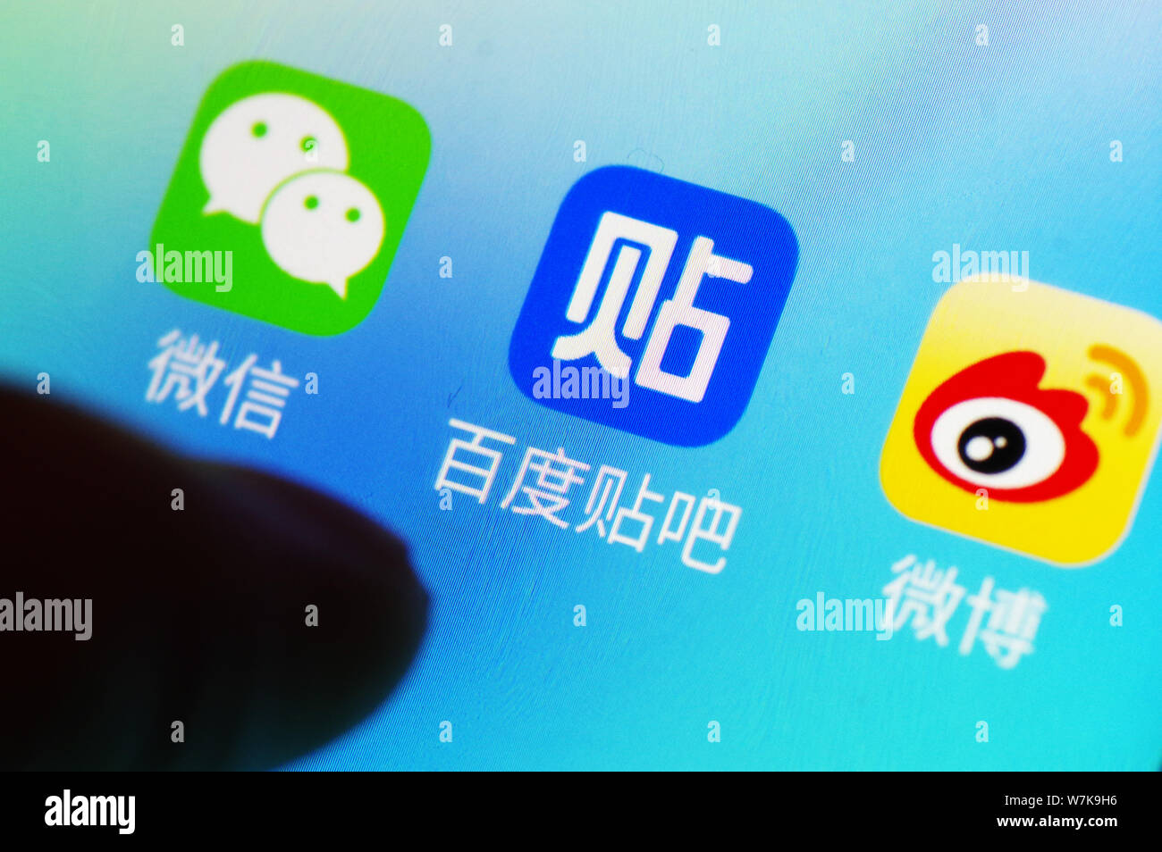 --FILE--un cinese utente del telefono mobile mostra le icone delle app di messaggistica Weixin o WeChat, sinistra, di Tencent, Baidu Tieba, centro e Weibo, a destra il T Foto Stock