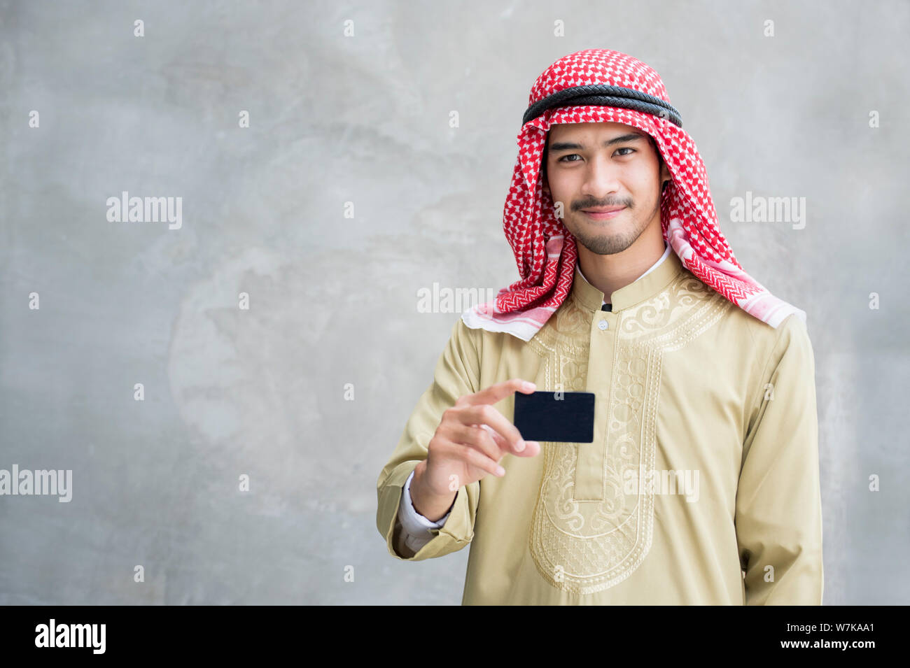 Sorridente bello arabian uomo azienda business card. Foto Stock