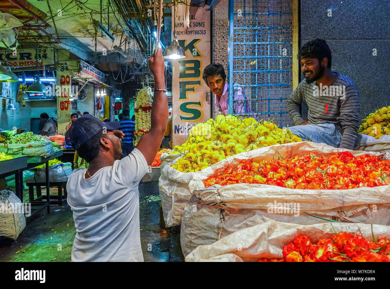La gente la vendita di fiori freschi in commercio all'ingrosso all'interno di KR il mercato dei fiori in India che è uno dei più grandi mercati di fiori in Asia Foto Stock