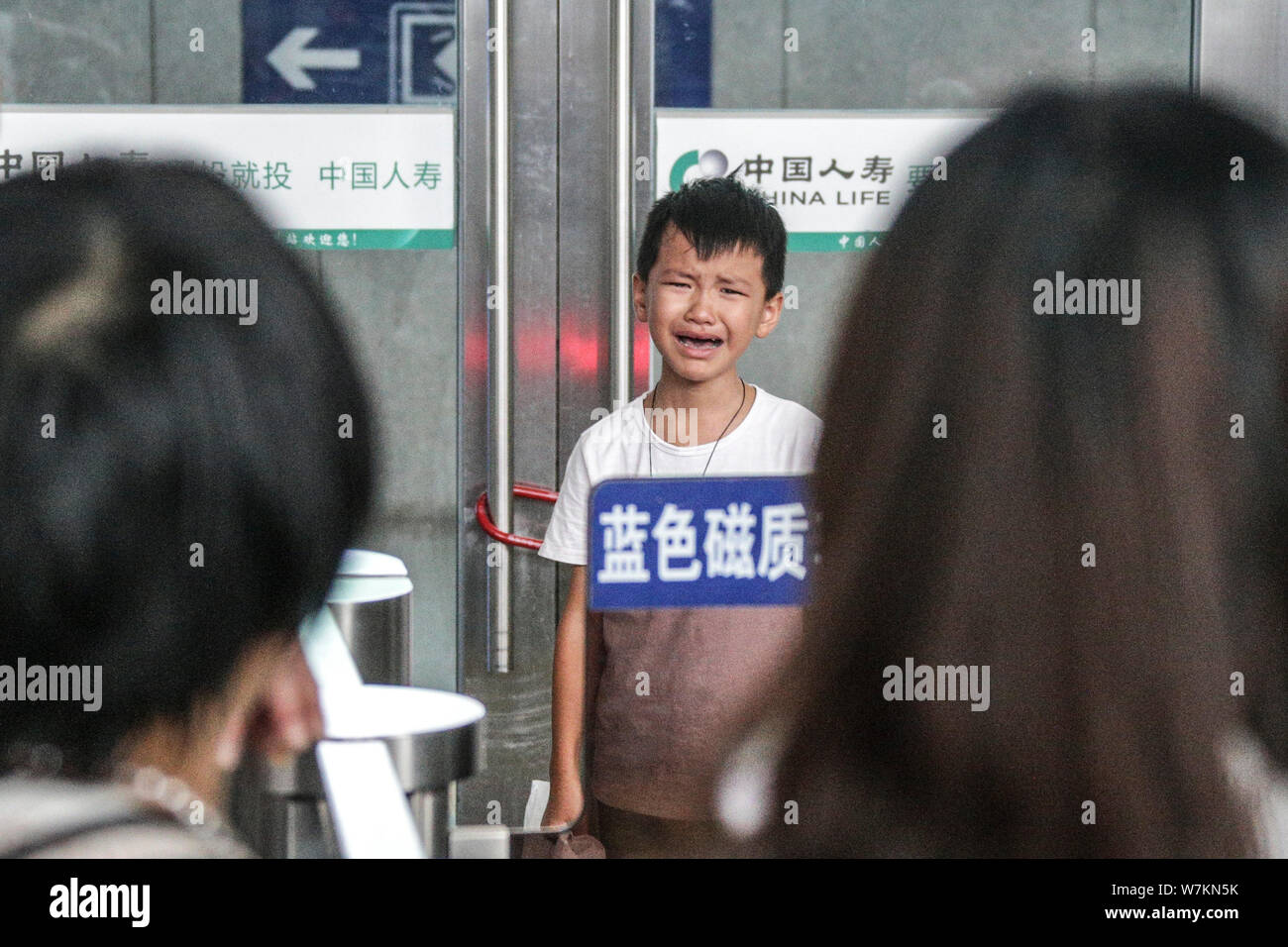 Sulla sinistra di un bambino dietro le lacrime dopo la separazione con sua madre a Quanzhou Stazione Ferroviaria di Quanzhou city, a sud-est della Cina di provincia del Fujian, 25 agosto Foto Stock