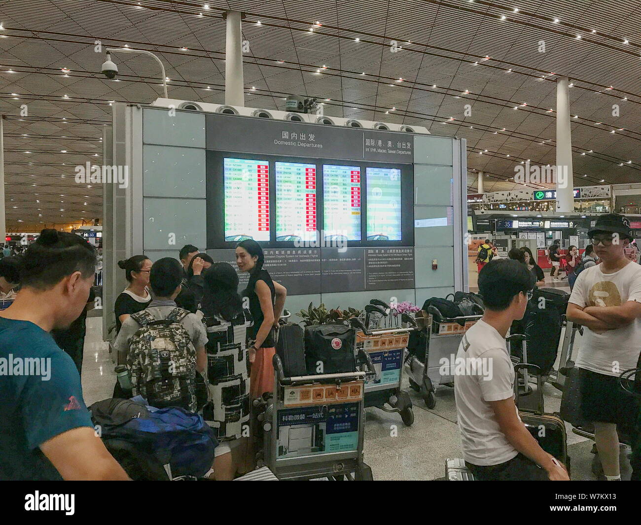 Passeggeri visualizza informazioni di volo su un tablet dopo enormi cancellazioni di voli a causa temporale presso l'Aeroporto Internazionale Capital di Pechino in bei Foto Stock