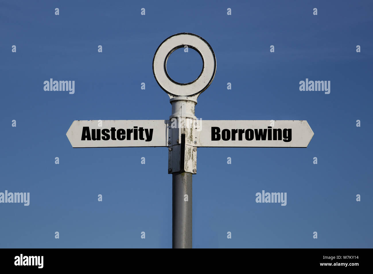 Vecchia strada segno con una scelta tra austerità e di assunzione di prestiti scritto su di esso. Governo politica fiscale concept Foto Stock