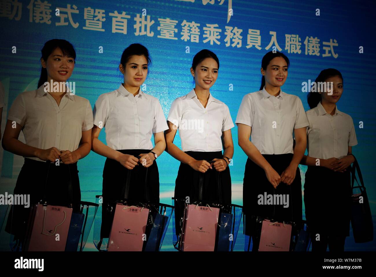 Air hostess del primo lotto di Xiamen Airlines Taiwan equipaggio di cabina assistere alla cerimonia di induzione nella città di Xiamen, a sud-est della Cina di provincia del Fujian, Foto Stock