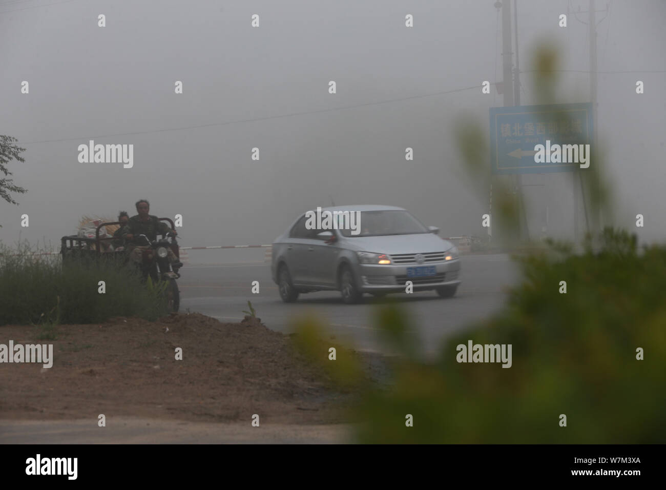 Un auto è visto vagamente nella fitta nebbia nella città di Yinchuan, a nord-ovest della Cina di Ningxia Hui Regione autonoma, 21 agosto 2017. Una fitta nebbia avvolta la Yinch Foto Stock