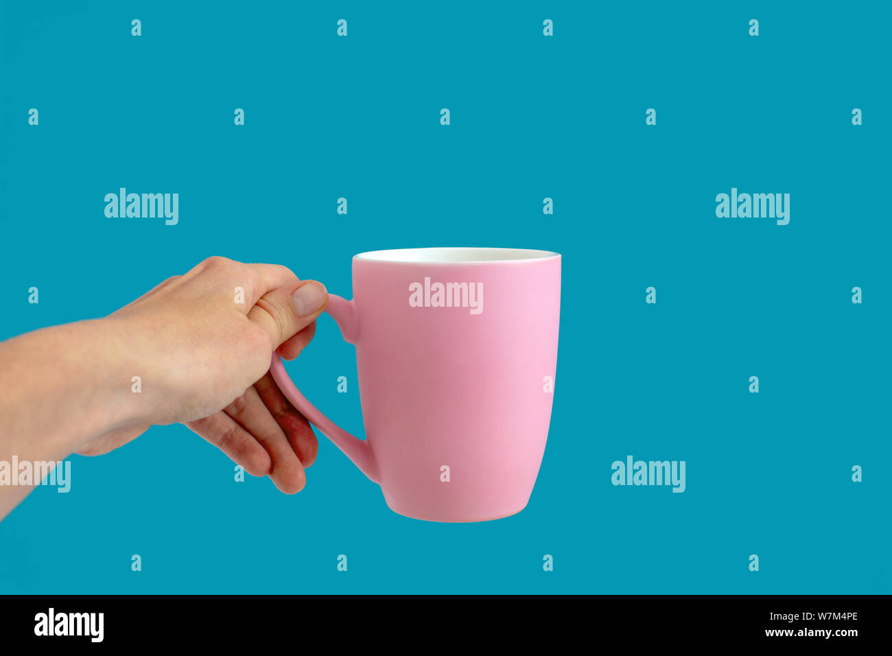 Persona che detiene la coppa rosa su sfondo blu Foto Stock