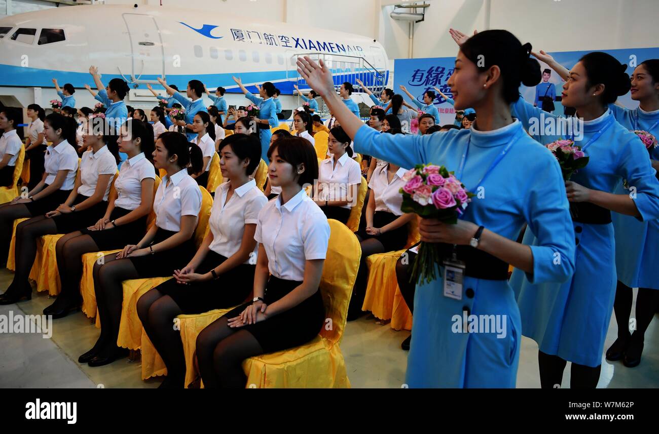 Air hostess del primo lotto di Xiamen Airlines Taiwan equipaggio di cabina assistere alla cerimonia di induzione nella città di Xiamen, a sud-est della Cina di provincia del Fujian, Foto Stock