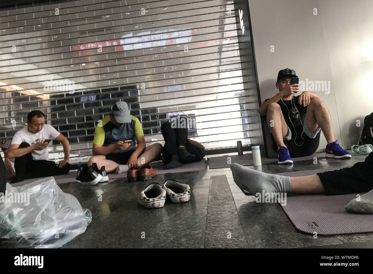 Esattori compresi alcuni dei suoi fornitori provenienti da tutta la contea sdraiarsi o sedersi su coperte e Materassini da yoga presso le sedi di Pechino di ch Foto Stock