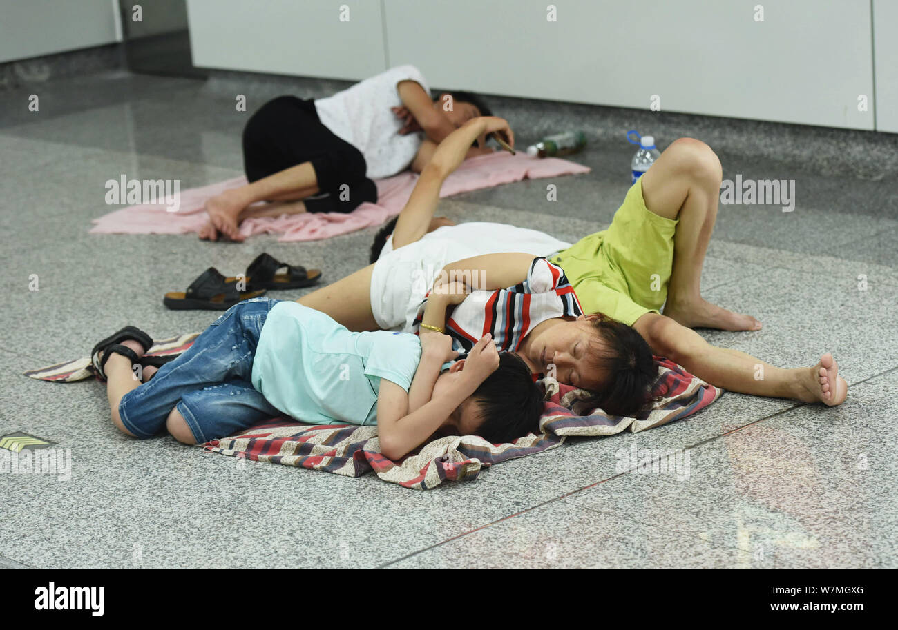 La gente di riposo in un'aria condizionata la stazione della metropolitana di sfuggire al caldo su un bruciante giorno nella città di Hangzhou, a est della Cina di provincia dello Zhejiang, 22 luglio 2017. Foto Stock