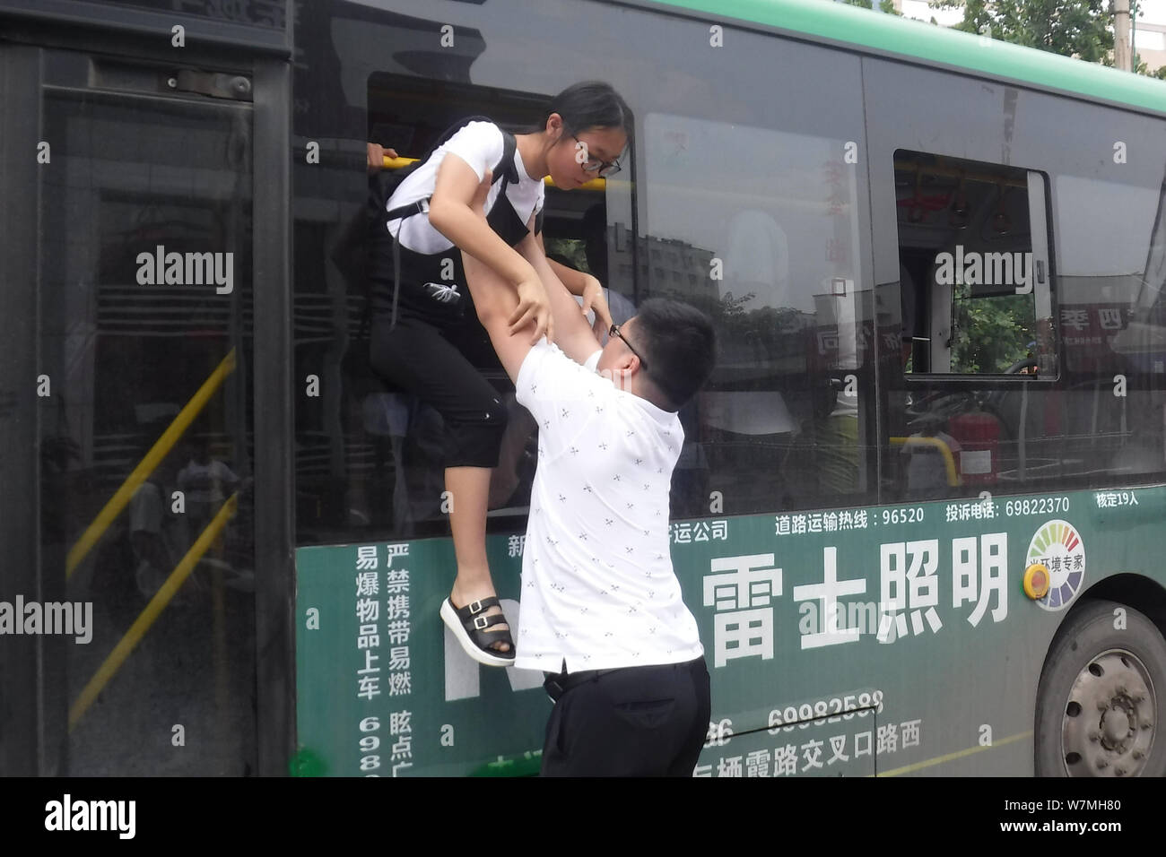 Un Cinese medio scuola studente salta fuori da un bus attraverso una finestra dopo un incidente stradale nella città di Xinmi, centrale cinese della provincia di Henan, 4 luglio 2017. T Foto Stock