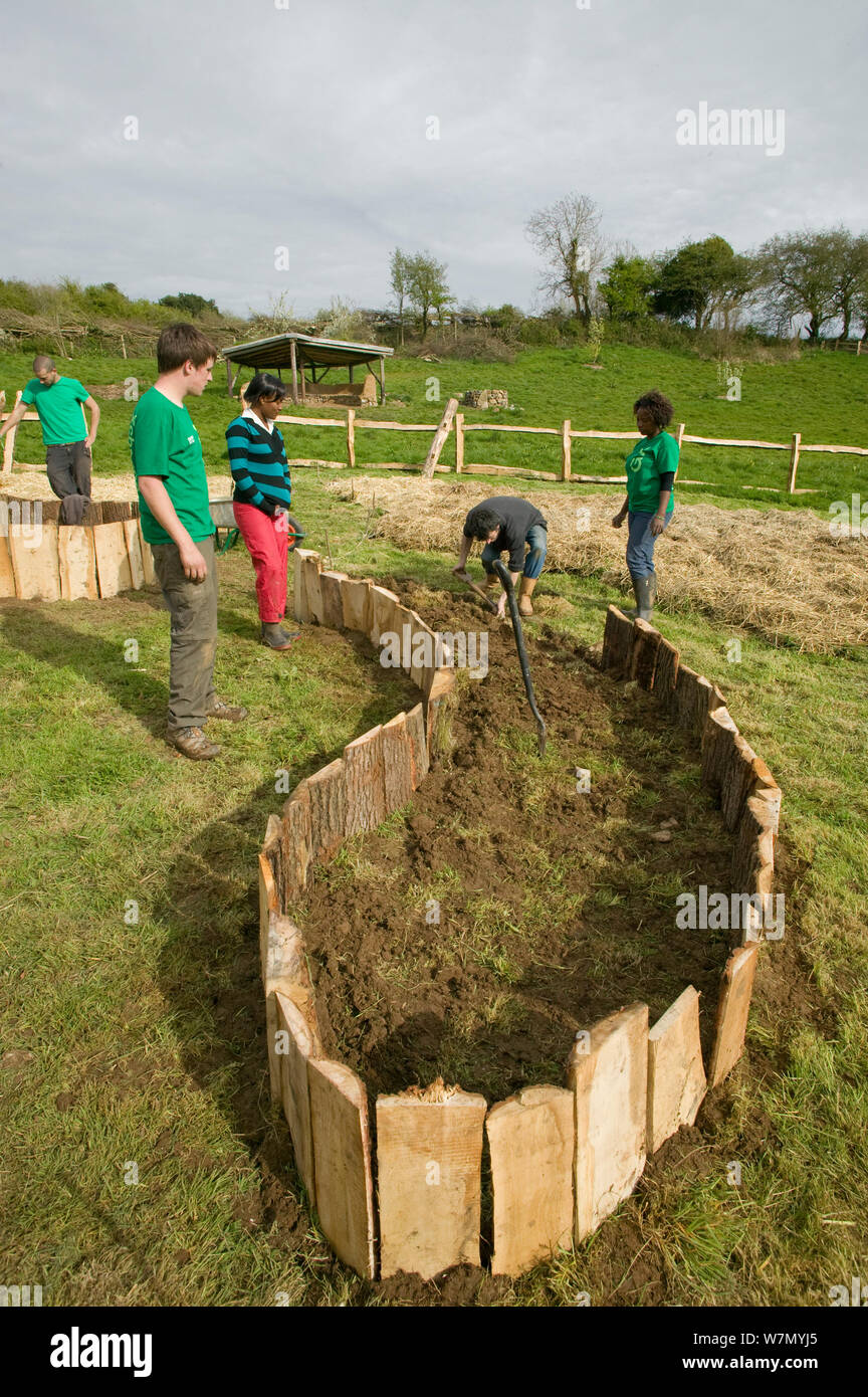 I giovani volontari aiutano a creare sollevata letti di semina per coltivare prodotti alimentari, giù per Terra progetto ambientale, Murton, Gower, South Wales, Regno Unito 2009 Foto Stock
