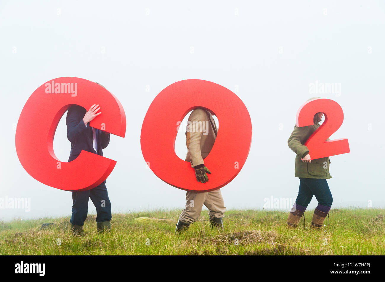 Persone azienda segni ortografia CO2, che rappresenta la cattura del carbonio per peatland sepoltura. Sutherland, Scozia, luglio 2012. Foto Stock