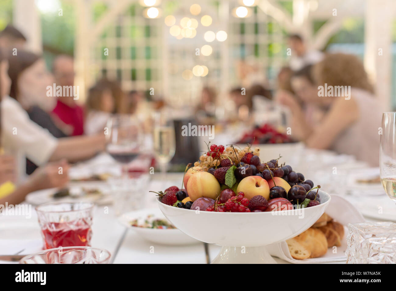 Ciotola bianco con frutta sulla tavola festiva Foto Stock