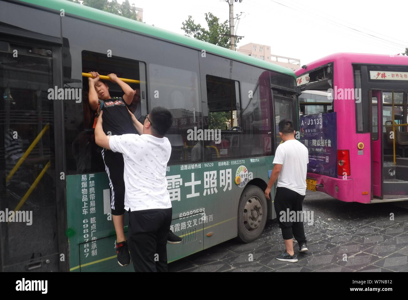 Un Cinese medio scuola studente salta fuori da un bus attraverso una finestra dopo un incidente stradale nella città di Xinmi, centrale cinese della provincia di Henan, 4 luglio 2017. T Foto Stock