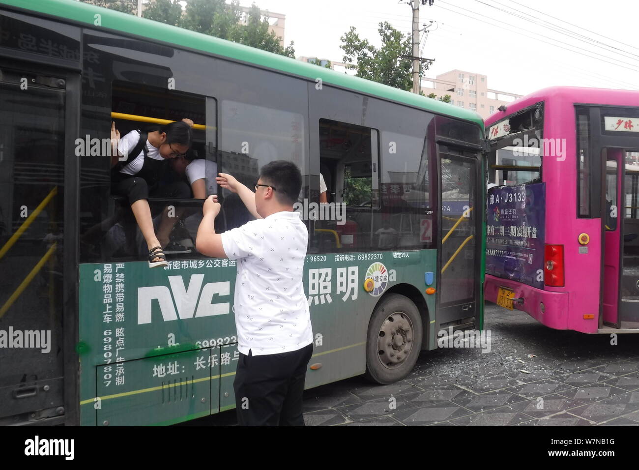 Un Cinese medio studente della scuola si prepara a saltare fuori di un autobus attraverso una finestra dopo un incidente stradale nella città di Xinmi, centrale cinese della provincia di Henan, 4 lug Foto Stock