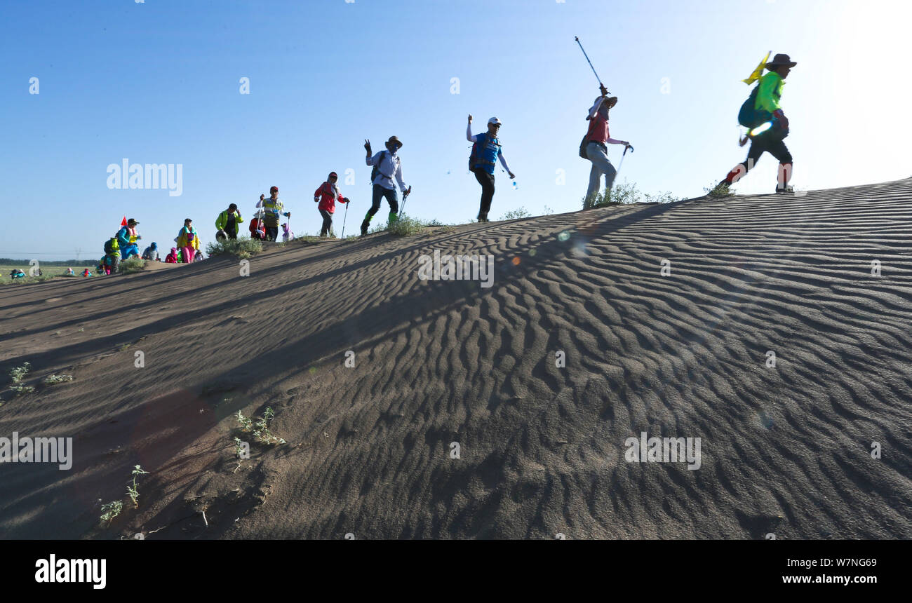 Gli appassionati cinesi a piedi nel deserto nazionale sports park durante un 10-chilometro escursioni nel deserto sfida la concorrenza nella città Zhangye, a nord-ovest della Cina di G Foto Stock