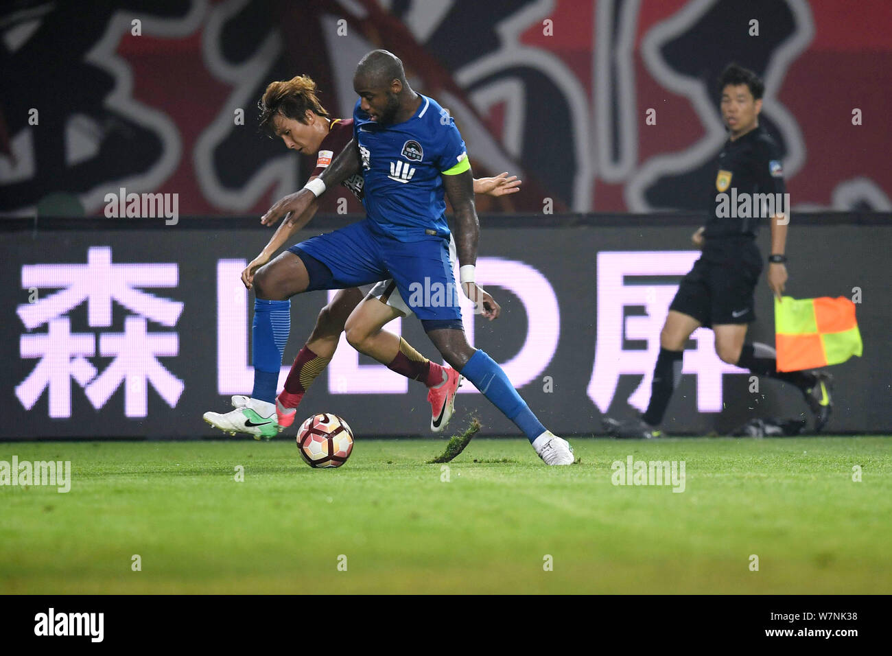 Il calcio danese player Edigeison Gomes, destro di Henan Jianye calci la palla per effettuare un sorpasso ai danni di un giocatore di Hebei Cina Fortune nel loro xvi rou Foto Stock