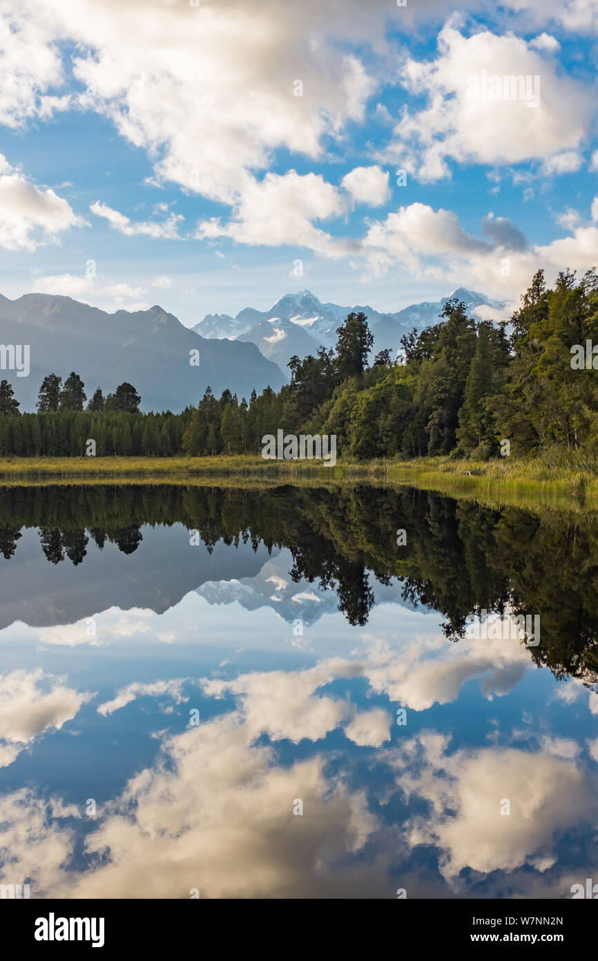 Un ritratto di visualizzazione incredibilmente il bellissimo Lago Matheson, Nuova Zelanda con la riflessione delle splendide Alpi del Sud e il maestoso Monte Cook Foto Stock