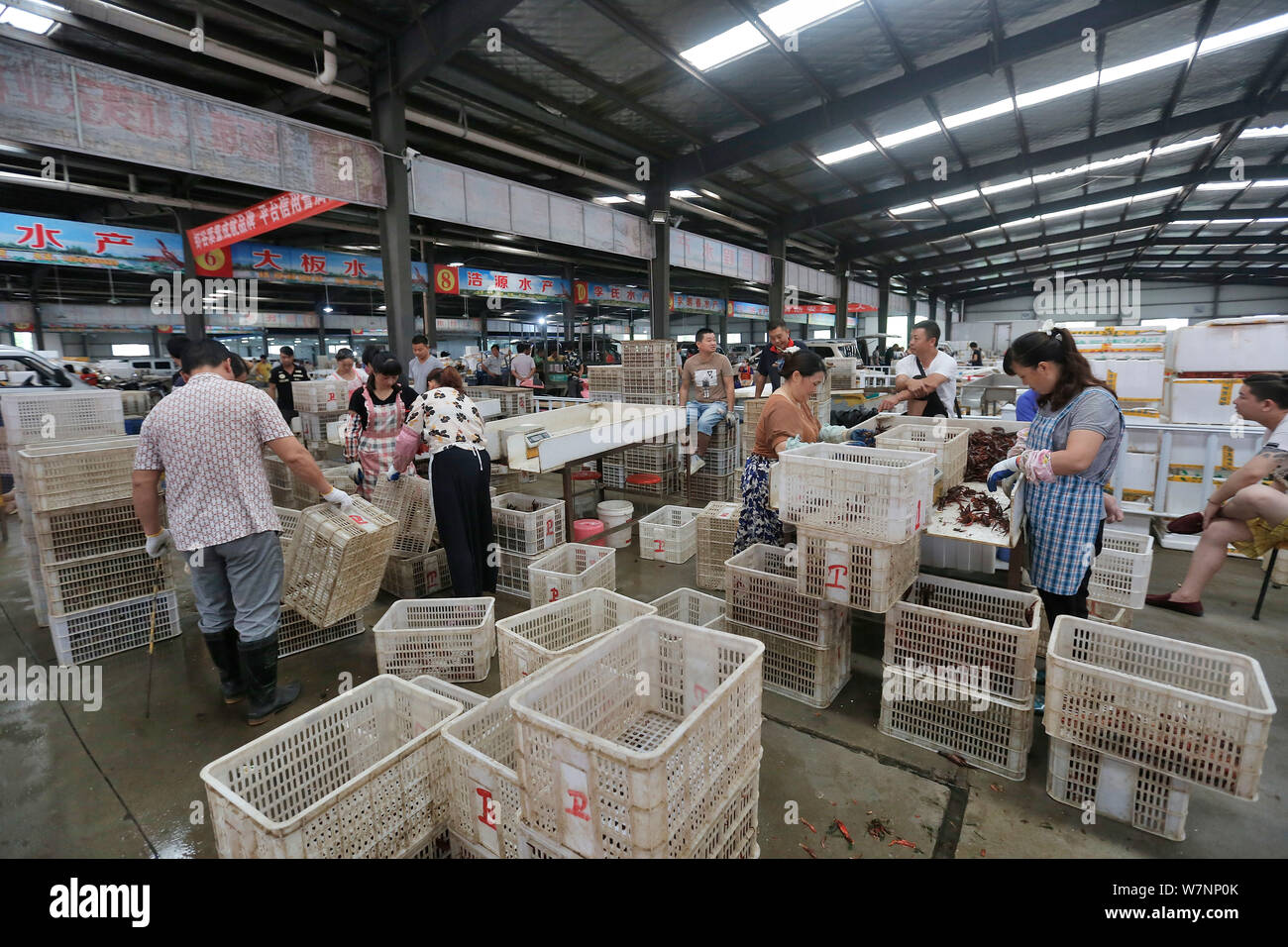 Lavoratori cinesi lavorare a un gambero sul mercato del commercio nella città di Qianjiang, centrale cinese della provincia di Hubei, 15 luglio 2017. Trenta anni fa, il gambero di fiume sono state accese Foto Stock