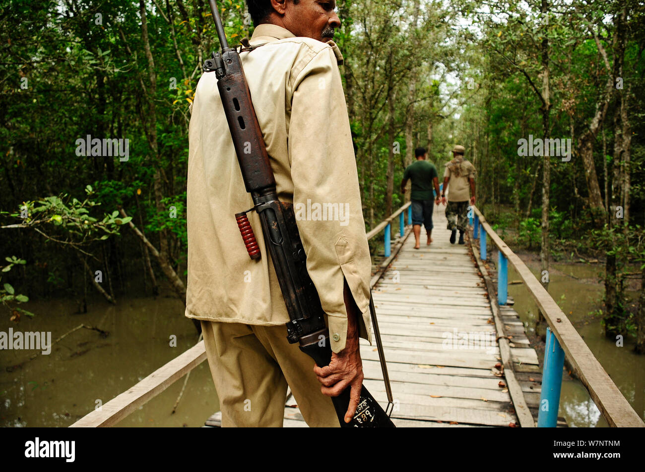 Guardie armate nel Parco Nazionale della Sundarbans. I gruppi turistici sono accompagnati da una guardia armata come questa zona ha la più grande popolazione di tigri in Asia, e anche il più alto numero di attacchi di Tiger su esseri umani, il Parco Nazionale della Sundarbans, Bangladesh. UNESCO - Sito Patrimonio dell'umanità. Giugno 2012. Foto Stock