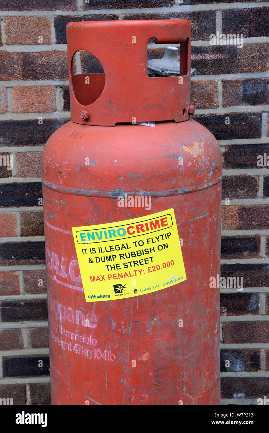 Envirocrime etichetta incollata su un cilindro con contenuto infiammabile oggetto di dumping Street London Borough di Islington, Regno Unito Foto Stock