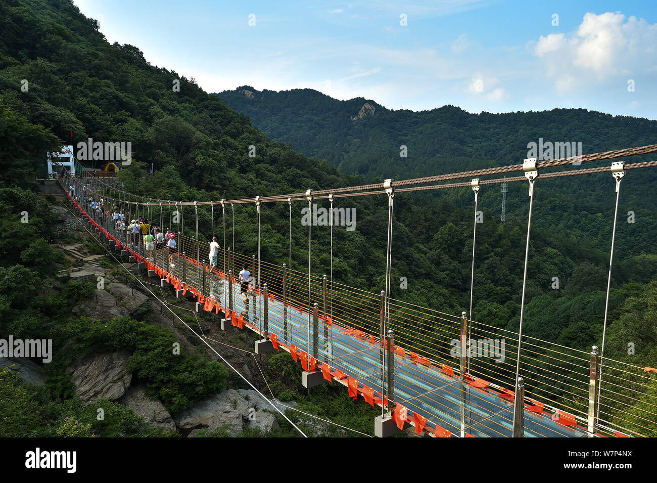 I turisti a piedi sulla montagna di attraversamento di sospensione ponte di vetro a Mulan Tianchi punto panoramico nella città di Wuhan, Cina centrale della provincia di Hubei, 18 giugno 201 Foto Stock