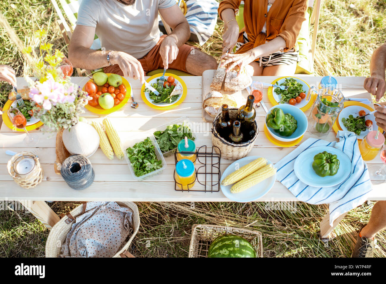 Le persone aventi il pranzo di festa in giardino con il cibo sano sul splendidamente decorate tabella, vista dall'alto Foto Stock