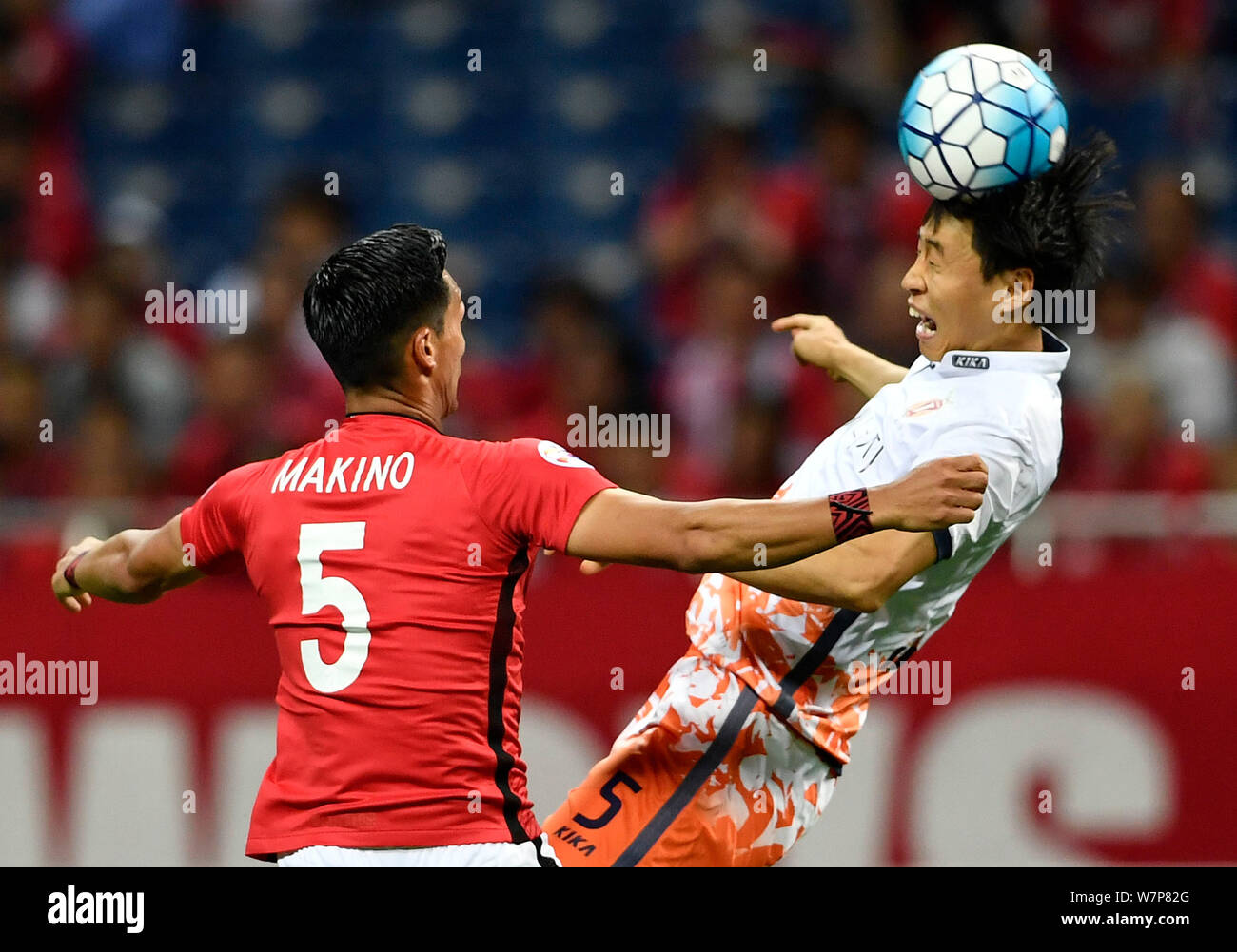 Tomoaki Makino del Giappone del Urawa Red Diamonds, sinistra, sfide Kweon Han-jin della Corea del Sud, Jeju uniti nella loro seconda tornata del 16 corrispondano durante il Foto Stock