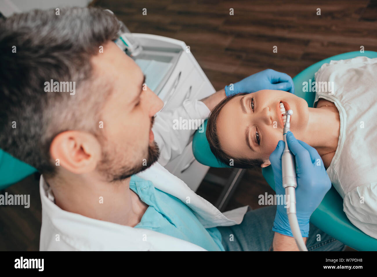Donna di ottenere la rimozione della placca con apparecchiatura dentale dal suo dentista presso la clinica Foto Stock