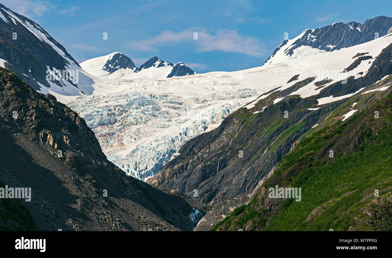 Primo piano di un ghiacciaio in Alaska vicino a portage e whittier circondato da montagne e con il cielo blu e nuvole gonfi in background Foto Stock