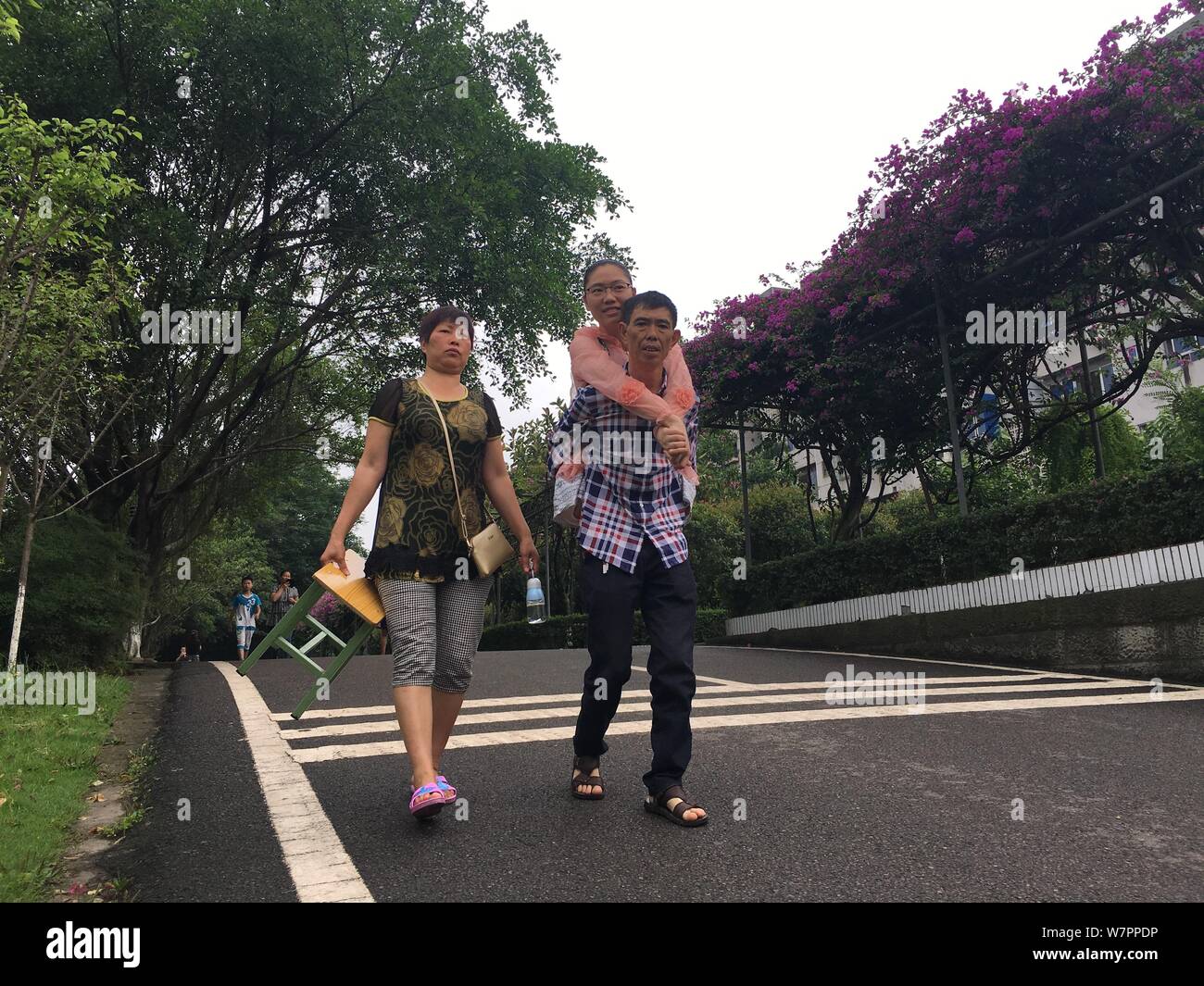 Cinese strumento "girl' Huang Huan è raffigurato con i suoi genitori dopo l'assunzione orale del test di inglese del 2017 Collegio Nazionale esame di ammissione, o Foto Stock
