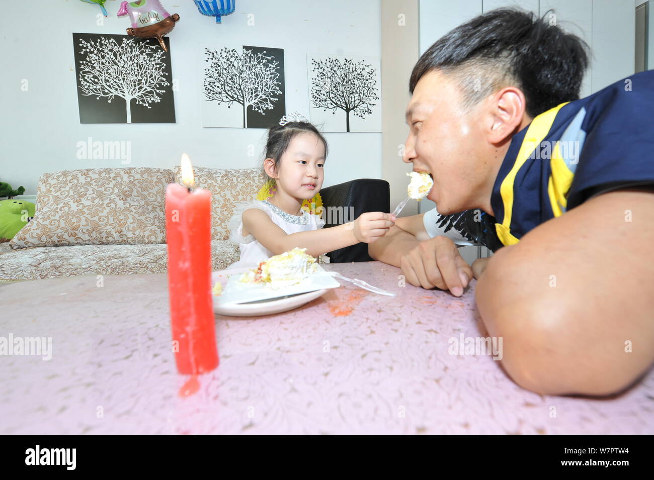Quattro-anno-vecchia ragazza Yin Haofei alimenta il padre con una torta per salutare la prossima Festa del Papà Baotou Città, a nord della Cina di Mongolia Interna autonome Foto Stock