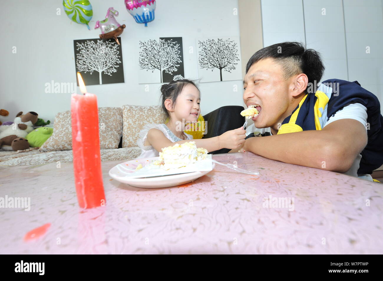Quattro-anno-vecchia ragazza Yin Haofei alimenta il padre con una torta per salutare la prossima Festa del Papà Baotou Città, a nord della Cina di Mongolia Interna autonome Foto Stock