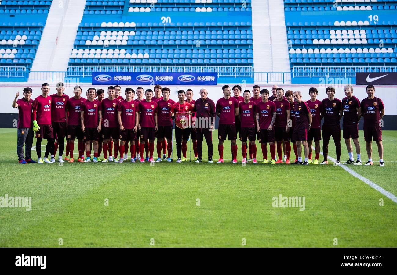 Capo allenatore Marcello Lippi della nazionale cinese gli uomini della squadra di calcio comporta per le foto con i suoi giocatori durante una sessione di formazione per una partita amichevole Foto Stock