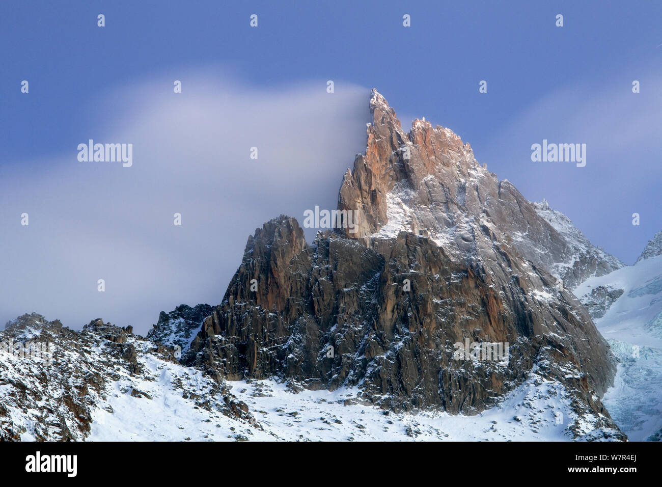 Montagne nella neve, Aiguille du Dru con raffiche di neve fuori dalla parte superiore di notte. Chamonix Haute Savoie, Francia, Dicembre 2011 Foto Stock