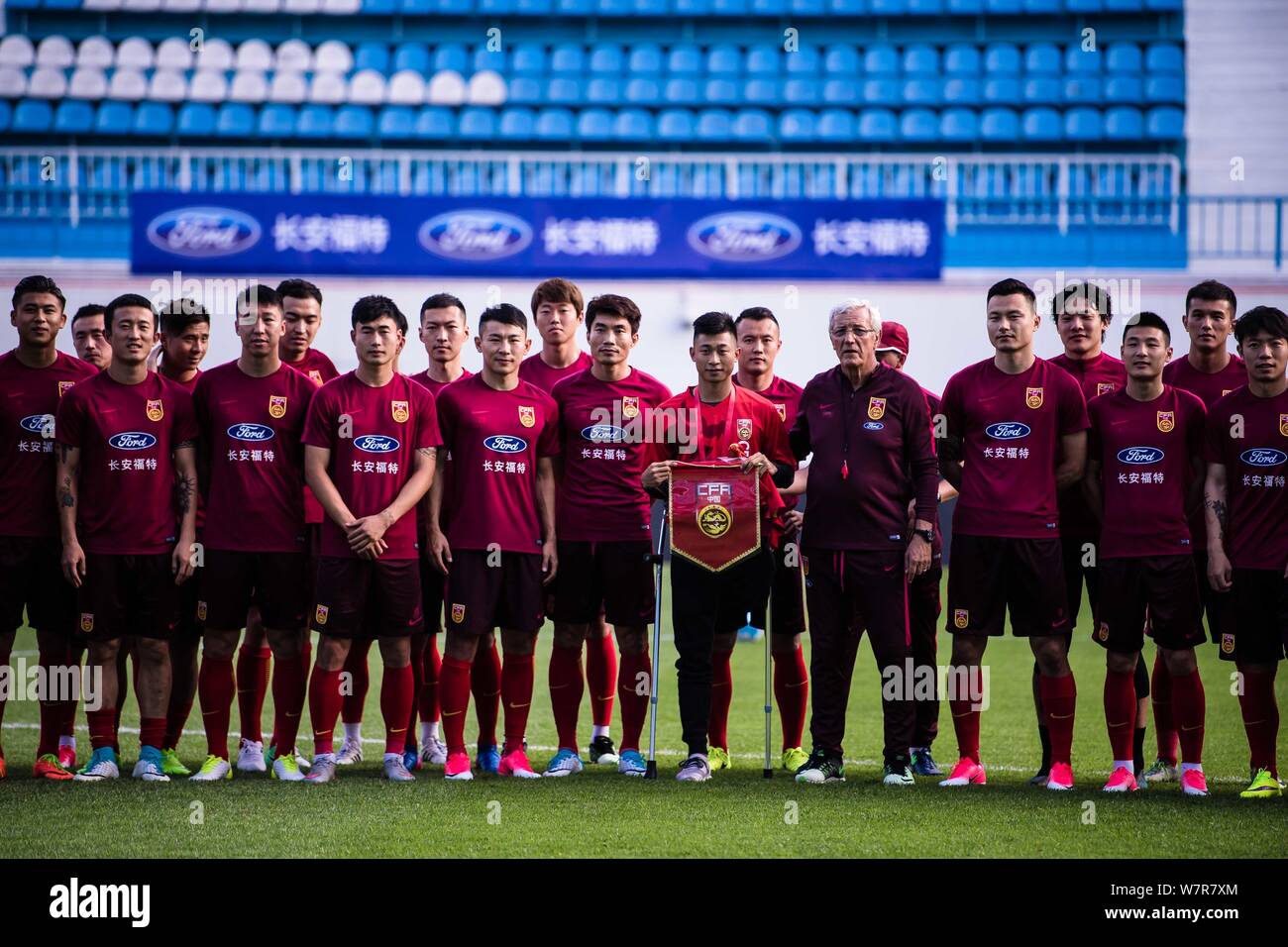 Capo allenatore Marcello Lippi della nazionale cinese gli uomini della squadra di calcio comporta per le foto con i suoi giocatori durante una sessione di formazione per una partita amichevole Foto Stock