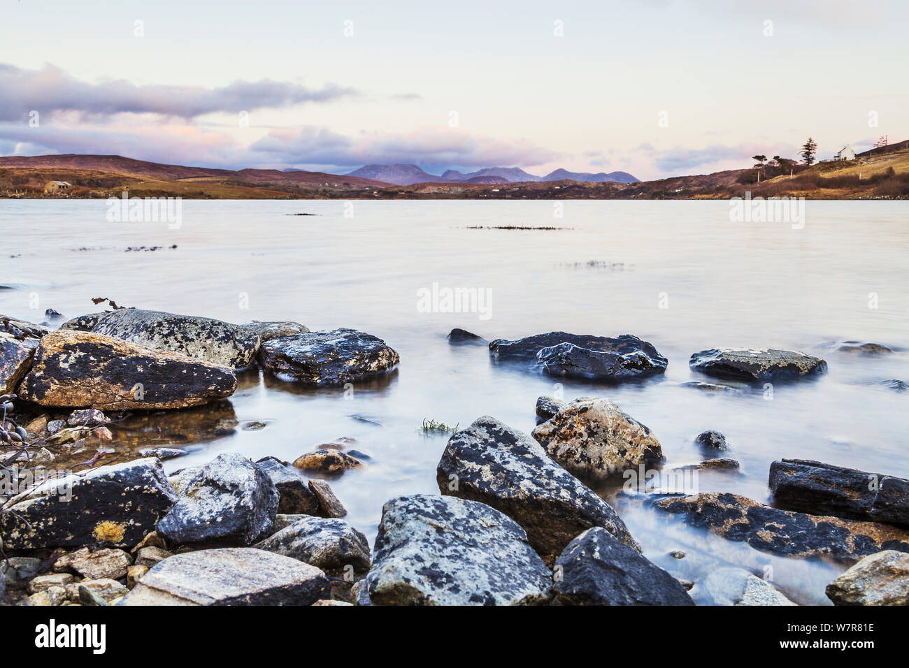 Tramonto su maree ingresso visto dal cielo Road, con le montagne sullo sfondo, vicino a Clifden, Connemara, Repubblica di Irlanda, marzo 2013. Foto Stock