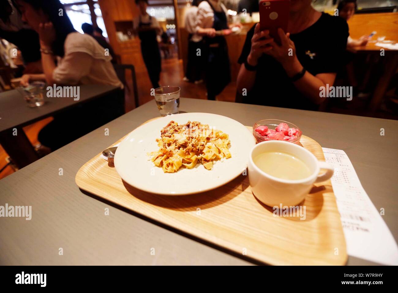 Un cliente cinese prende la foto di un piatto al mondo il primo MUJI Diner su Huaihai Road in Cina a Shanghai, 4 giugno 2017. Il primo al mondo MUJI DIN Foto Stock