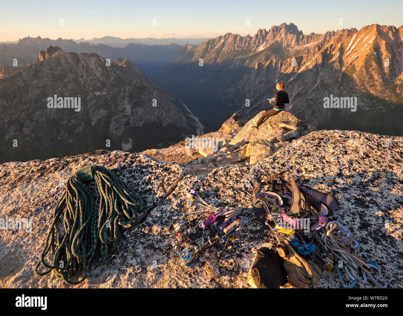 Donna godendo il vertice viste al tramonto dopo la scalata alla vetta del Liberty Bell attraverso il percorso Beckey, vicino a Washington Pass in North Cascades, Washington, Stati Uniti d'America , Luglio 2013 Foto Stock
