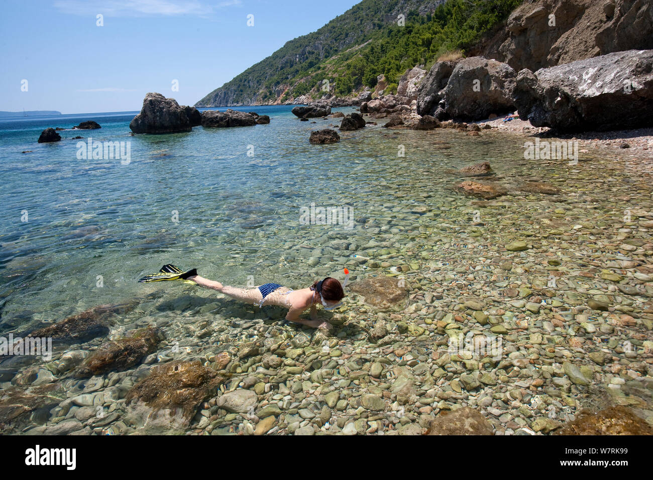 La donna lo snorkeling di fronte alla spiaggia di Komiza, Isola di Vis, Croazia, Mare Adriatico, Mediterranea Foto Stock