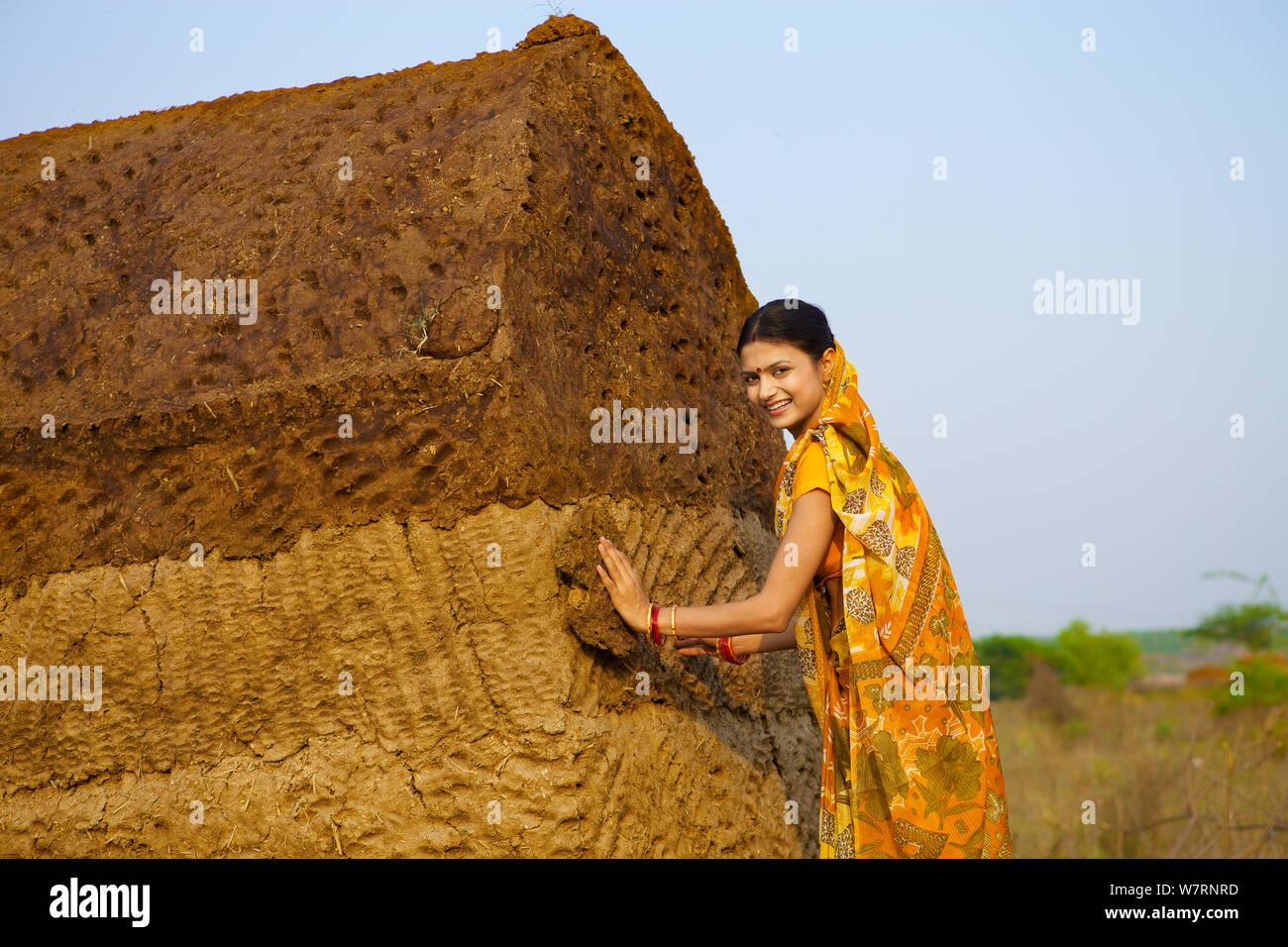 Donna rurale con sterco torta hut Foto Stock