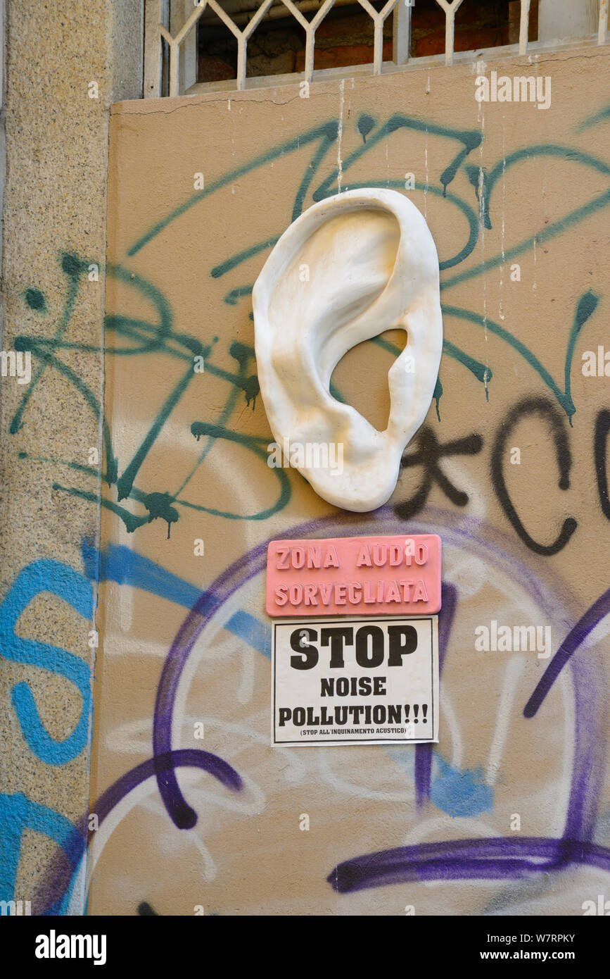 L'Italia, Lombardia, Milano, quartiere dei Navigli, Via Sartirana Street, la scultura di un orecchio fissato ad una parete della zona è sotto sorveglianza Audio Foto Stock