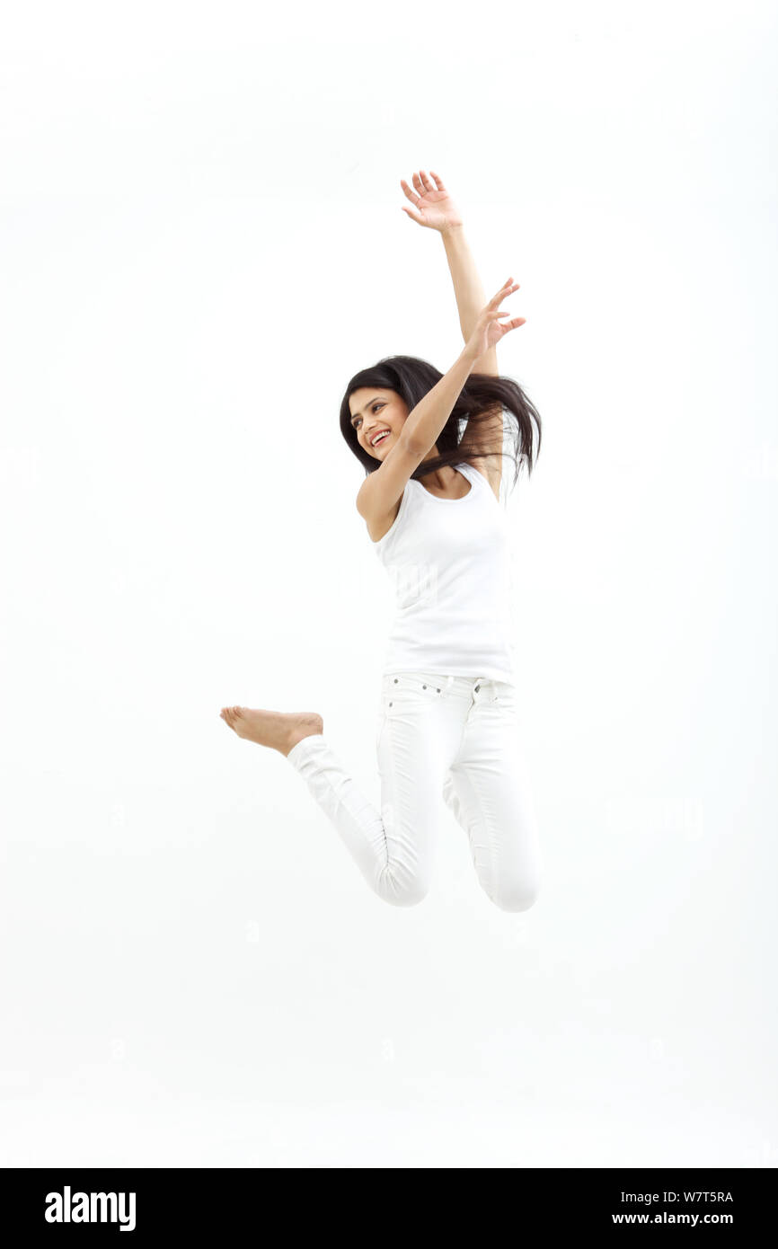 Giovane donna jumping a metà in aria Foto Stock