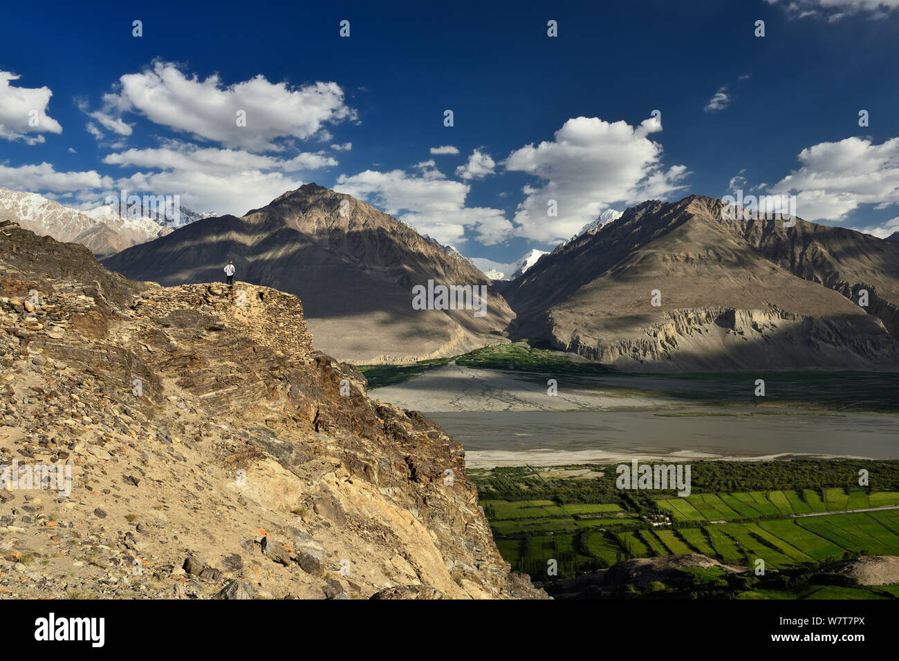 Vista sulla valle di Wakhan nel Pamir mountain, turistico in piedi sulle rovine del Yamchun Fort cercando sul bianco Hindu Kush gamma in Afghanistan, T Foto Stock