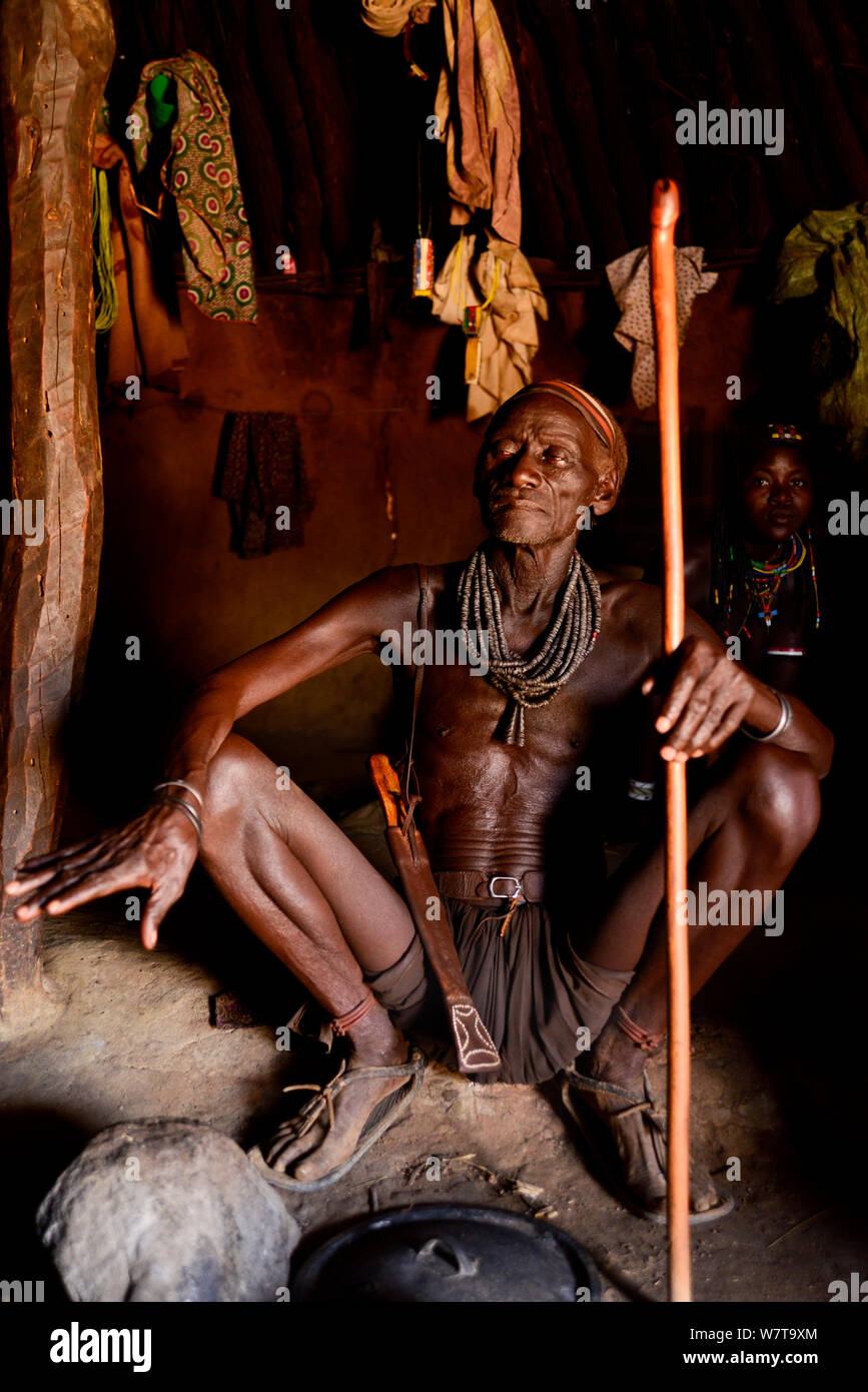 Il vecchio uomo Ovahakaona con personale in baita, Kaokoland, Namibia. Foto Stock