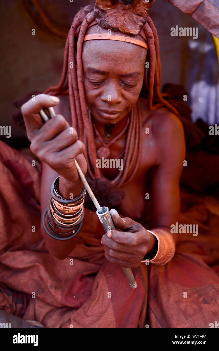 Donna Himba sbuffare nasale il tabacco da fiuto. Kaokoland, Namibia, settembre 2013. Foto Stock