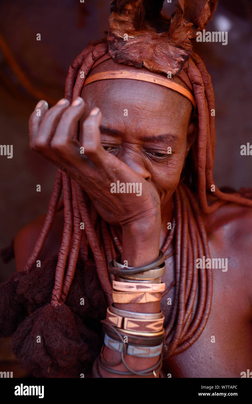 Donna Himba sbuffare tabacco da fiuto. Kaokoland, Namibia, settembre 2013. Foto Stock