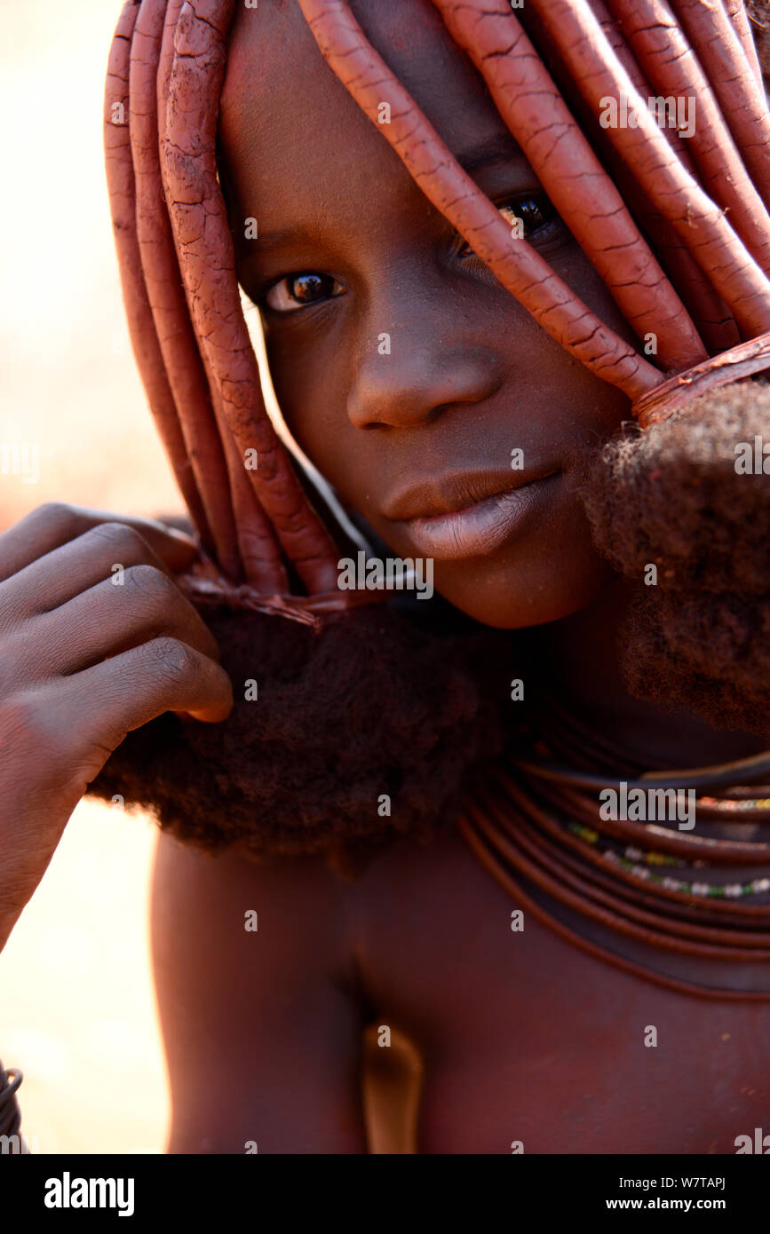 Ritratto di donna Himba con caratteristica Otjize (un mix di burro di cenere e ocra) che copre i capelli e la pelle, Kaokoland, Namibia. Foto Stock