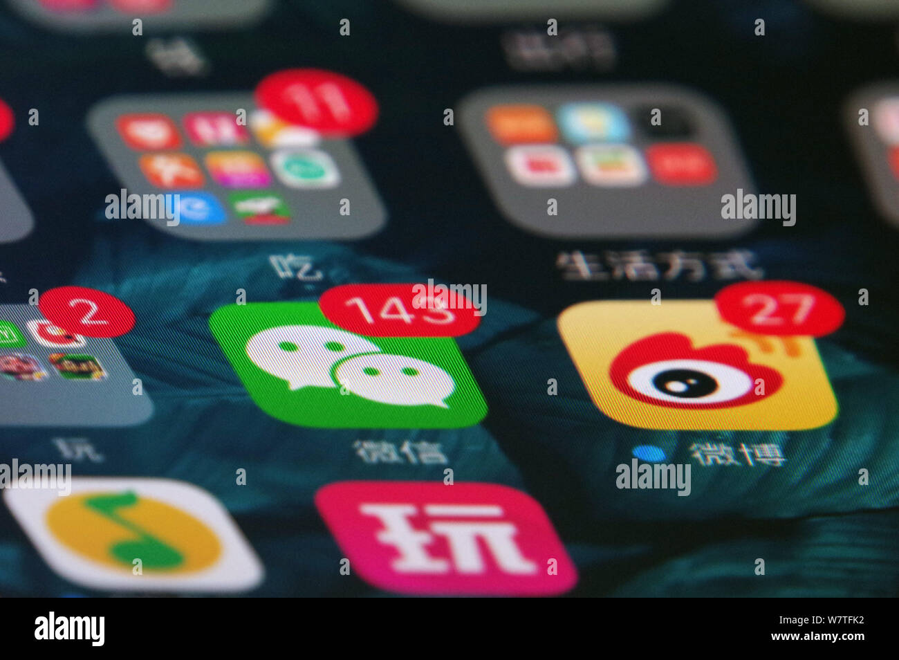 --FILE -- un telefono cellulare utente guarda le icone delle app di messaggistica Weixin, centro o WeChat, di Tencent e Weibo, destra, il Twitter-come microbloggin Foto Stock