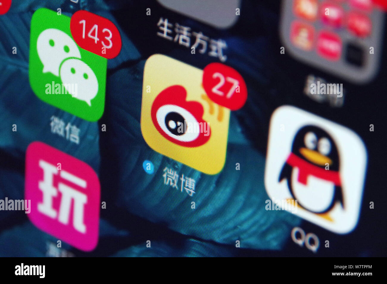 --FILE -- un telefono cellulare utente guarda le icone delle app di messaggistica Weixin, sinistra o WeChat, QQ, destro di Tencent e Weibo, centro, il Twitter-come mi Foto Stock