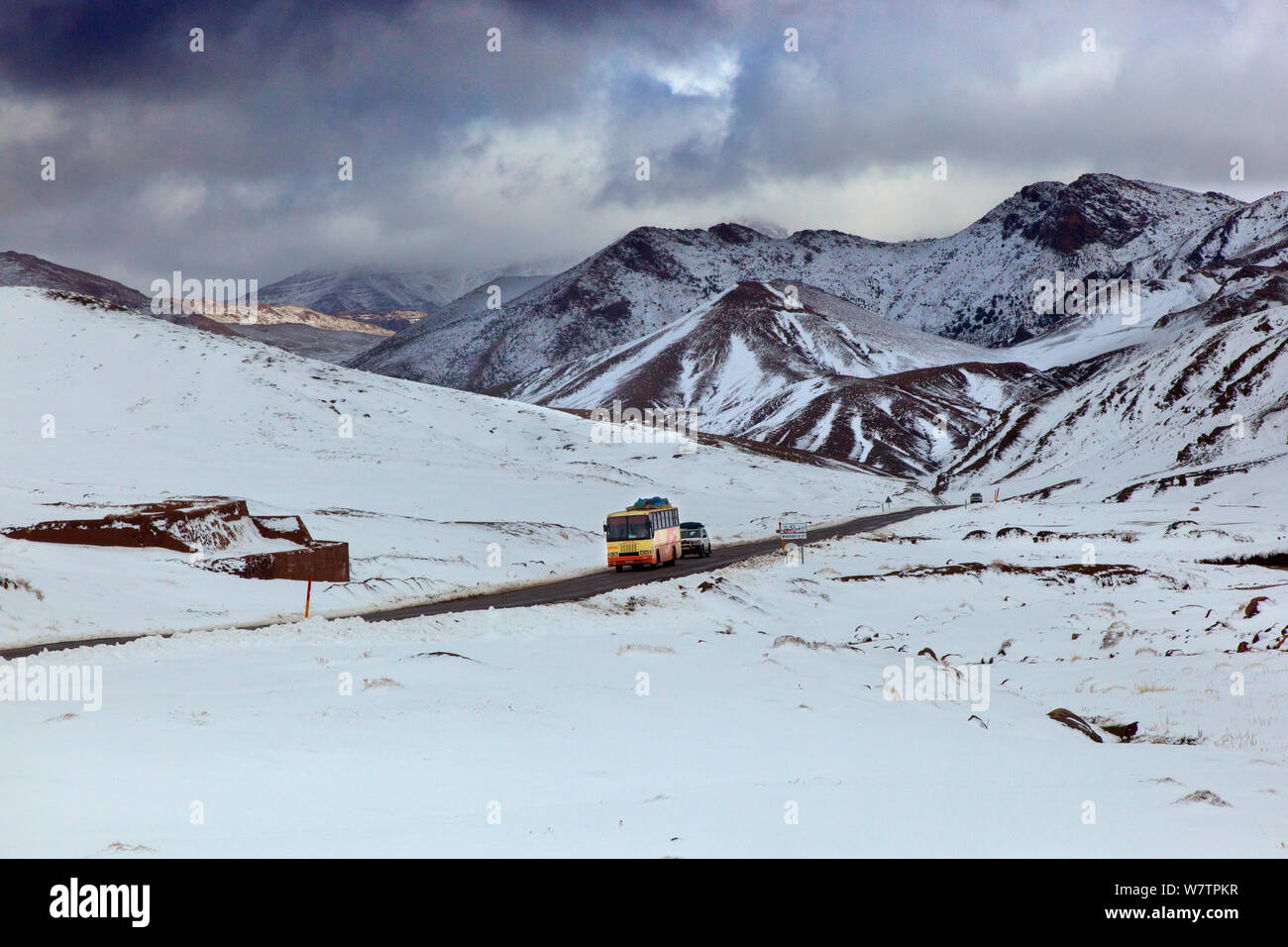 Bus e auto sulla strada che attraversa le montagne Atlas in fine di neve, Marocco, Africa del Nord, marzo 2011. Foto Stock